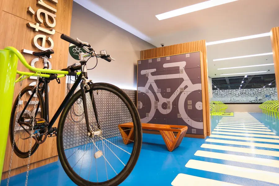 Bicicleta pendurada em um bicicletário dentro de um ambiente corporativo